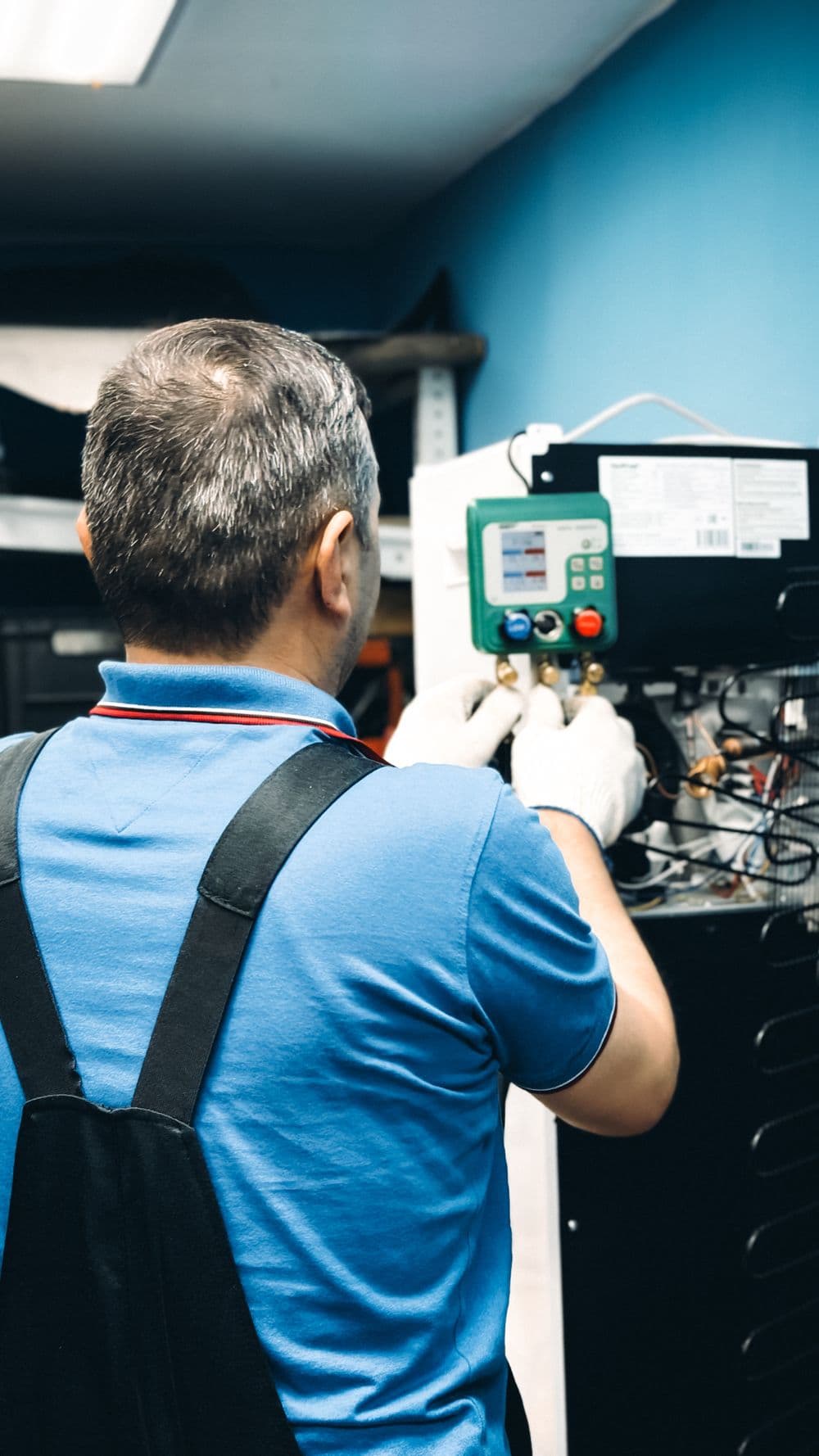 Technician maintaining an air conditioning unit